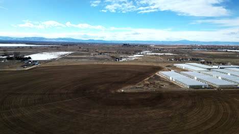 greenhouses and expansive acreage of an agricultural land in brighton, colorado
