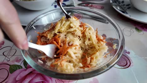 anciana ama de casa mixta de ensalada con verduras y frutas con horquillas