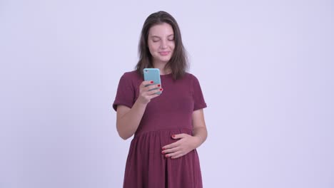 happy young beautiful pregnant woman with phone