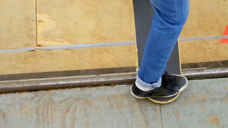 Low-section-of-young-man-doing-skateboard-trick-on-skateboard-ramp-at-skateboard-court-4k