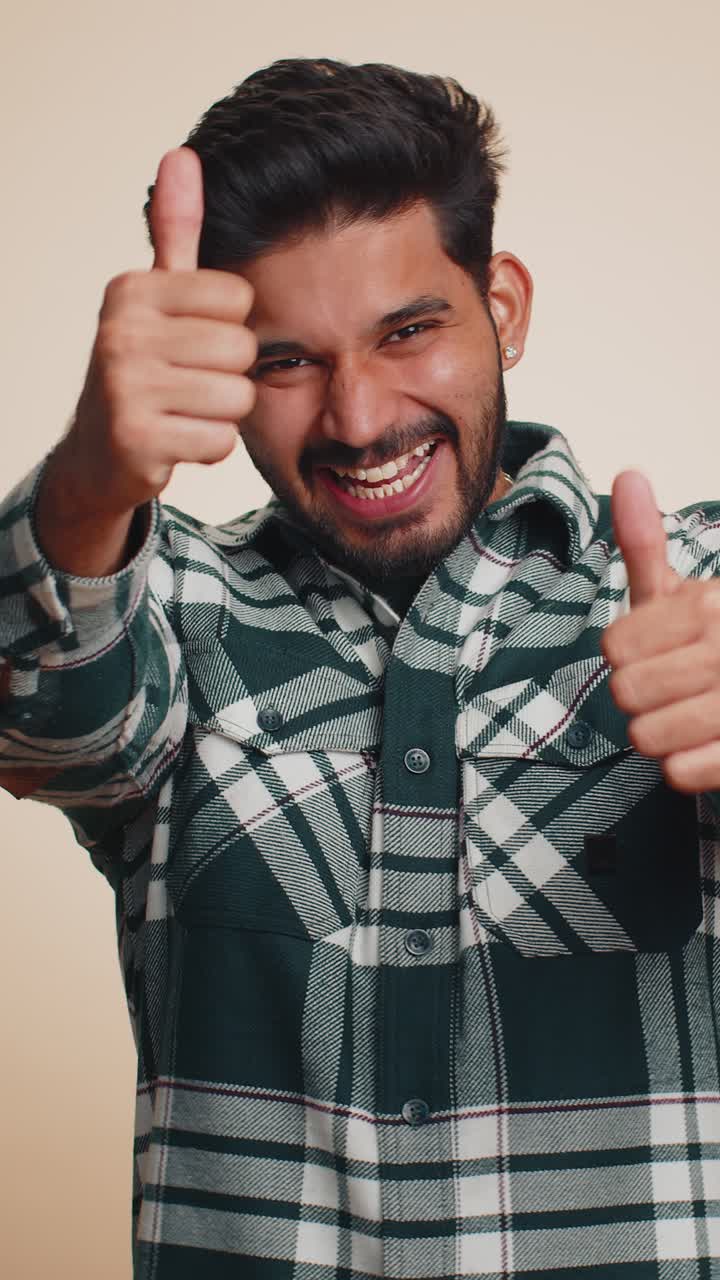 Il giovane indiano alza il pollice, accetta o risponde positivamente, raccomanda l'annuncio, gli piace bene.