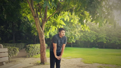 health conscious fat man practicing stretching workout at public park during morning sunrise