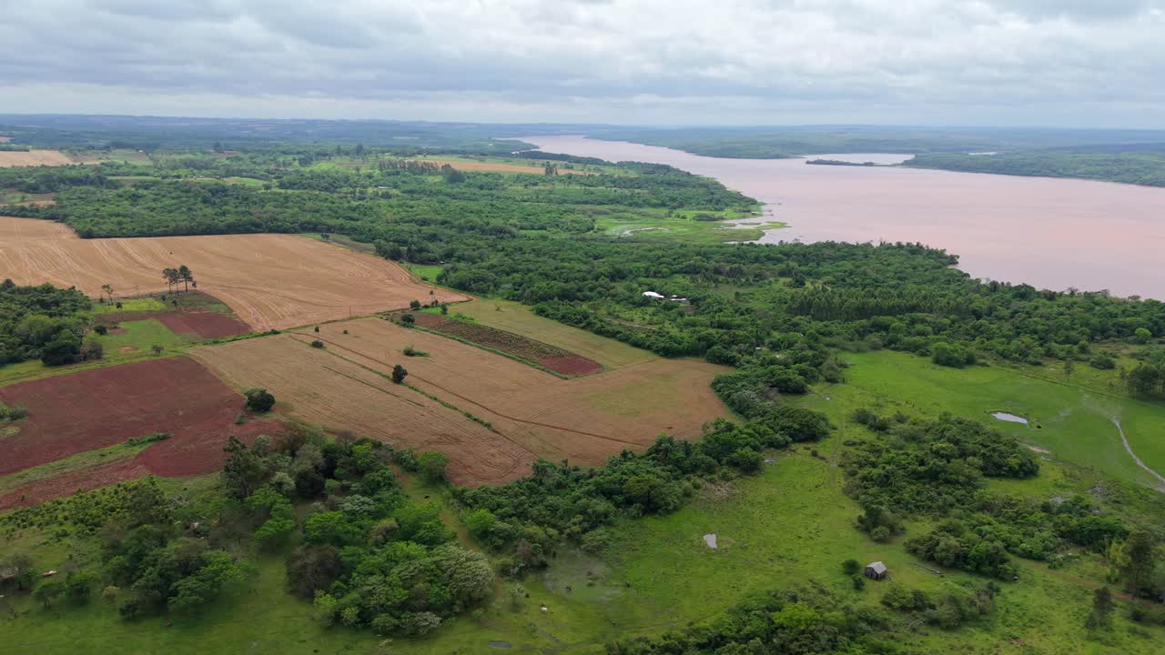 Drone image showing a mosaic of cultivated fields, commercial plantations, and native forest patches in Campichuelo, Paraguay, under an overcast sky