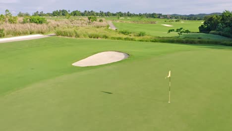 golf course of vistas golf and country club in santo domingo and waving flag, dominican republic