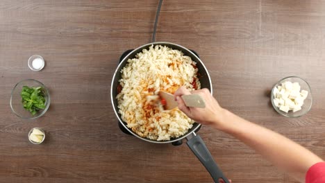 Toma-De-Arriba-Hacia-Abajo-De-La-Combinación-De-Pasta-Fusilli-Con-Salsa-De-Tomate-En-Una-Sartén-Grande,-Usando-Una-Espátula-De-Madera