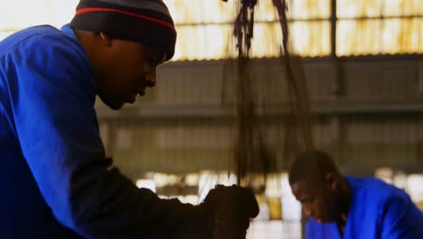 close-up of workers putting soil in metal mold in foundry workshop 4k