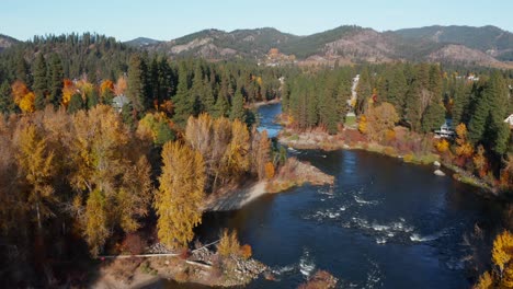 Aerial-view-of-fast-blue-river-surrounded-by-the-forest-in-Washington,-USA