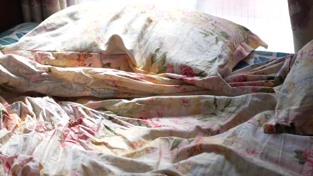 неподготовленная кровать с цветочной постелью