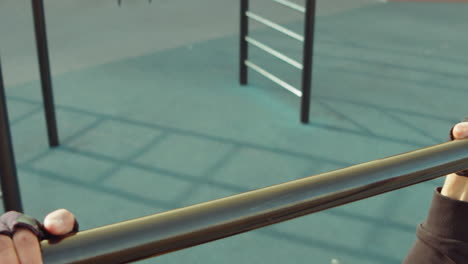 man exercising on pull-up bar at workout playground