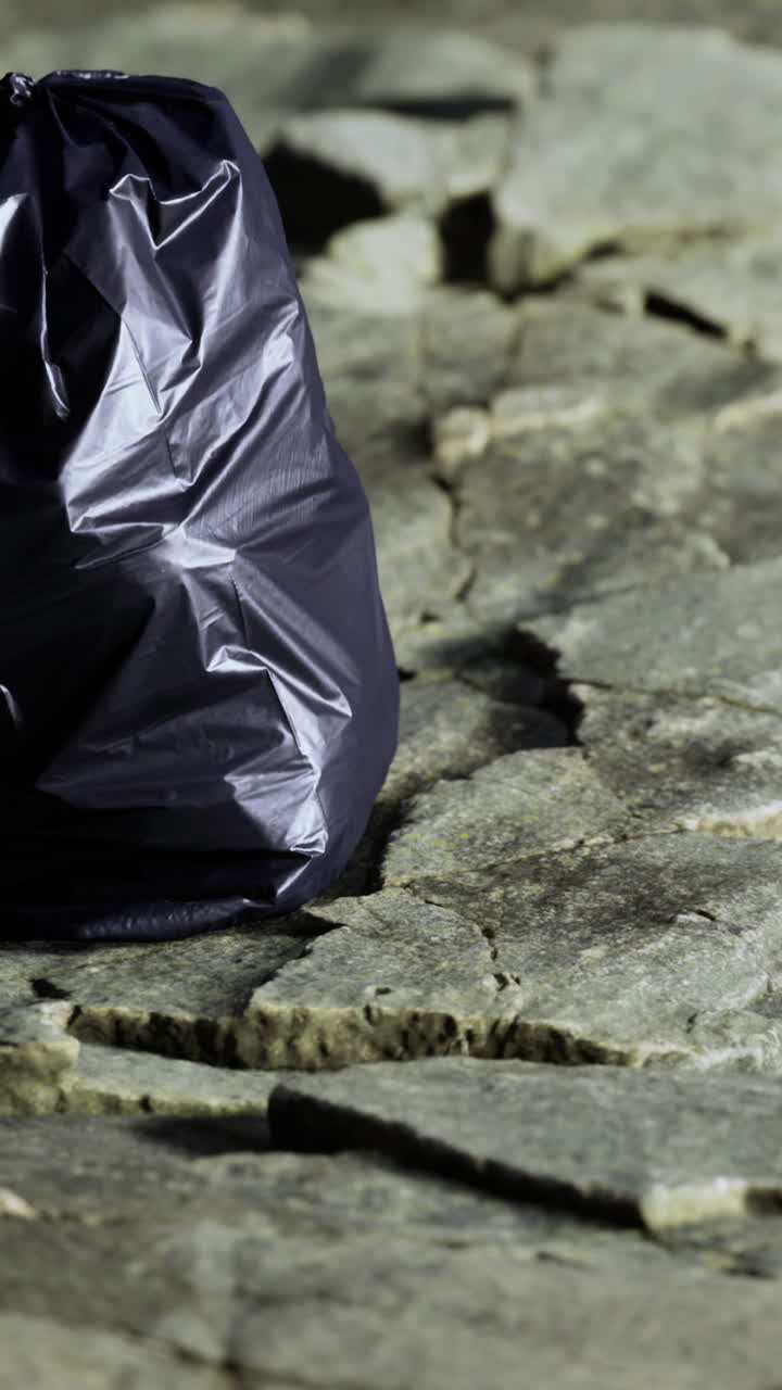 Una borsa nera solitaria è posizionata con cura su una superficie ruvida