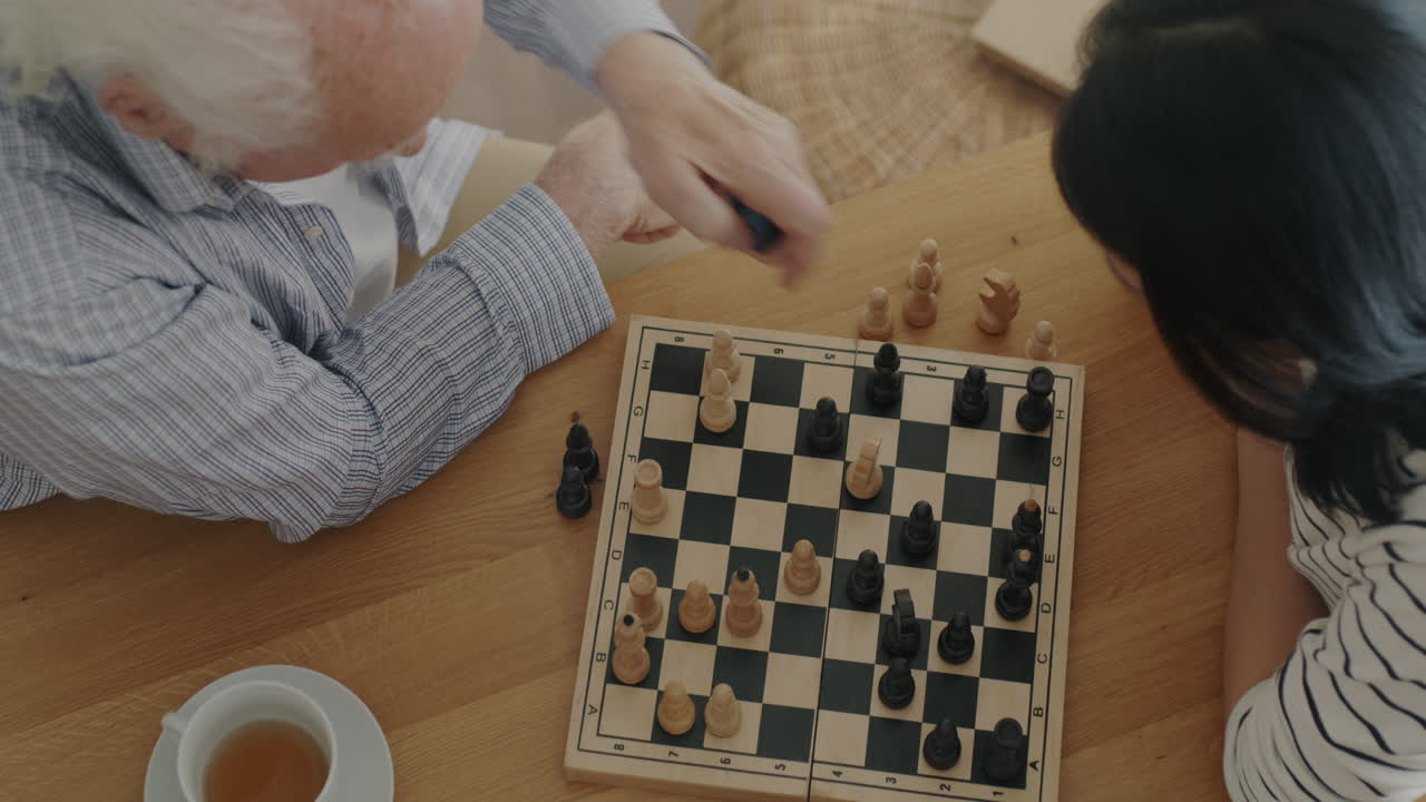 Una pareja de mayores jugando al ajedrez.