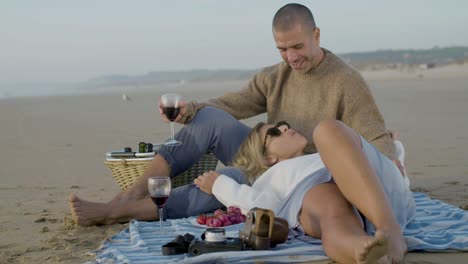 romantic caucasian couple having picnic at seashore together.