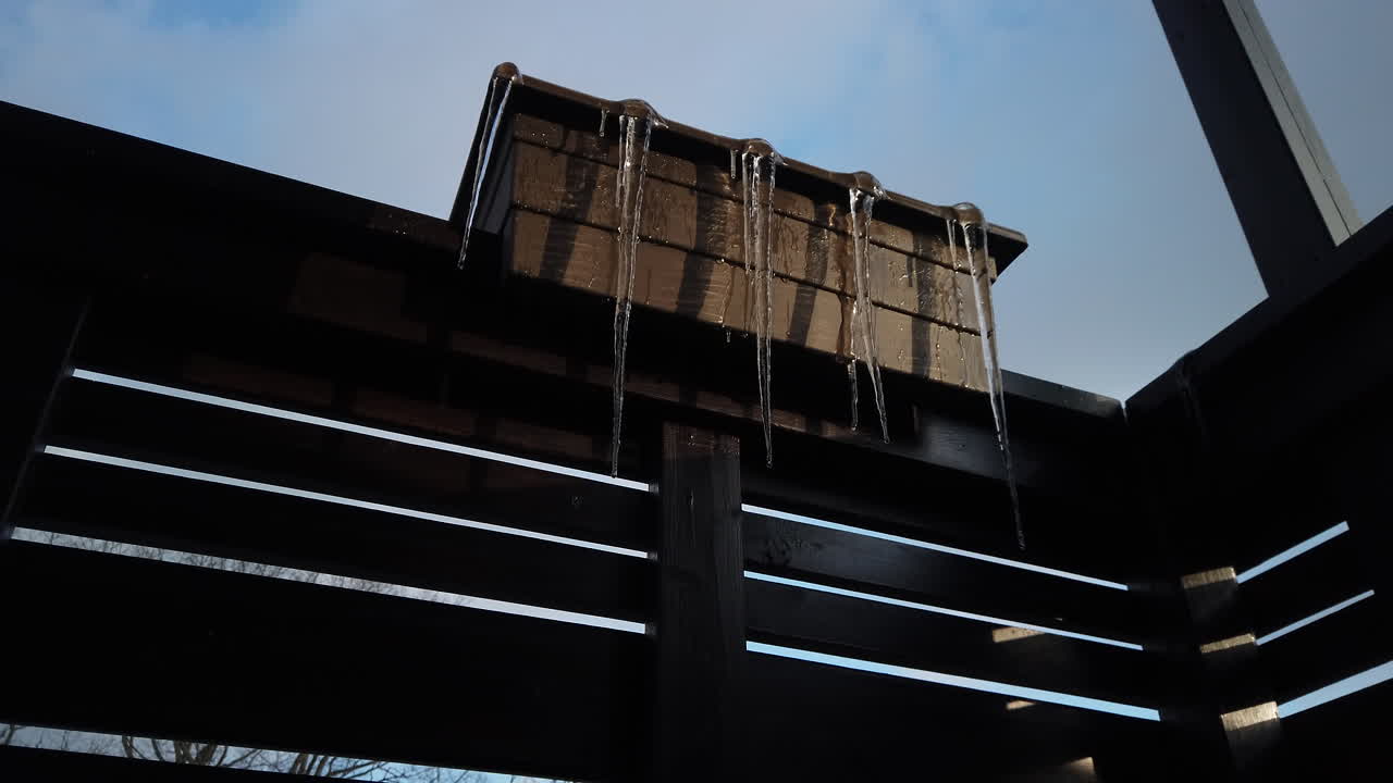 carámbanos de daga largos derritiéndose en una jardinera de balcón