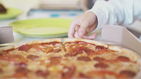 el escolar toma un delicioso pedazo de pizza en un primer plano de la mesa.