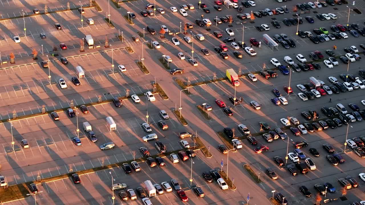 Late afternoon drone shot, half full parking lot with warm sunlight reflections