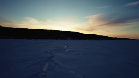 flying drone above a frozen lake in canada at golden hour