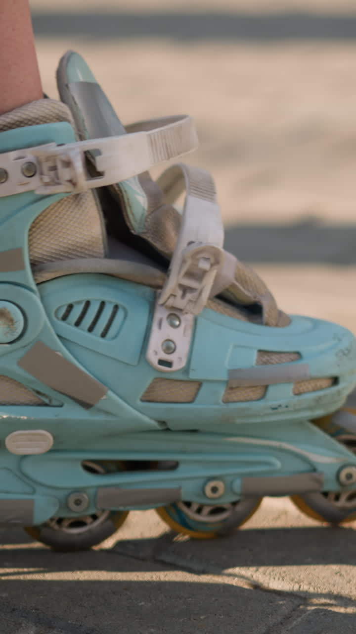 Side view of individual adjusting strap on roller skate of right leg with black wristband under bright sunlight, white sneakers partially in view, background softly blurred