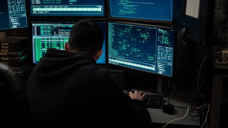 man hacking or working on computers with multiple monitors