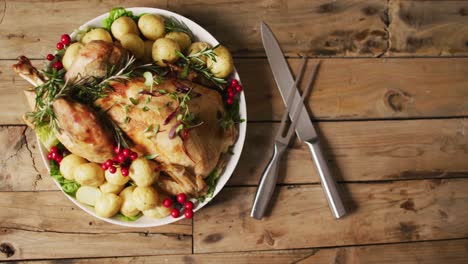 video of tray with roasted turkey, potatoes and cutlery on wooden surface