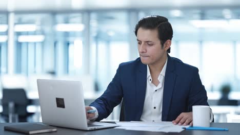 confused indian corporate employee working on laptop