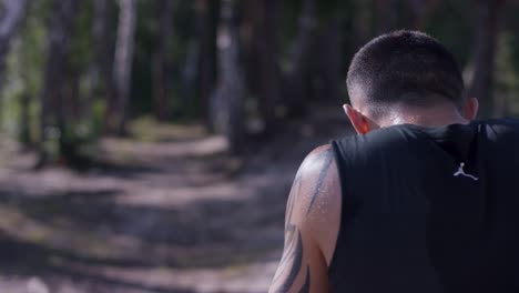 man resting in a forest after exercise