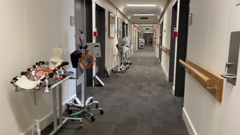 looking down hospital corridor with medical equipment wide shot