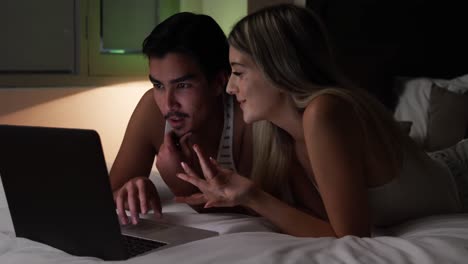 pareja feliz mirando la computadora en su casa