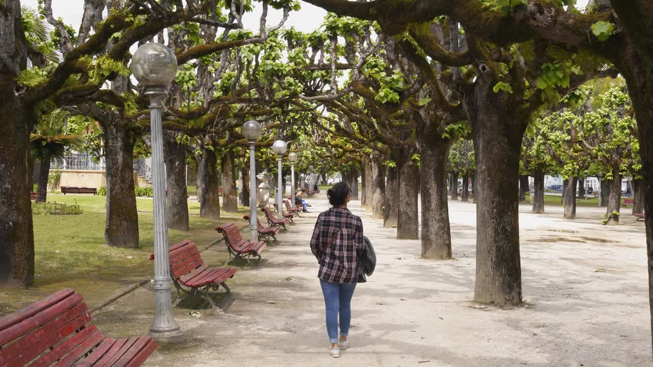 Woman traveler walking in Manuel Braga park in Coimbra, Portugal