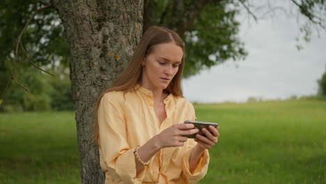 Mujer-Joven-Jugando-En-El-Teléfono-Móvil,-Al-Aire-Libre