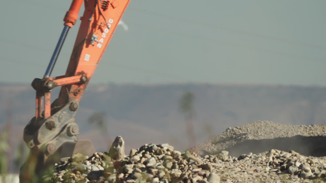 Close Up of an Excavator Digging and Moving Rocks at a Construction Site