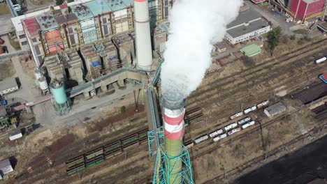 Aerial-view-of-flue-gas-stack,-coal-fired-thermal-power-plant-and-air-pollution,-toxic-gas-goes-into-atmosphere,-high-angle-drone-shot