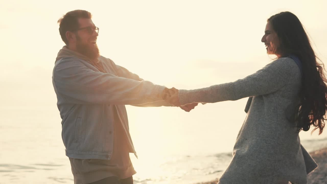pareja bailando en la playa al atardecer