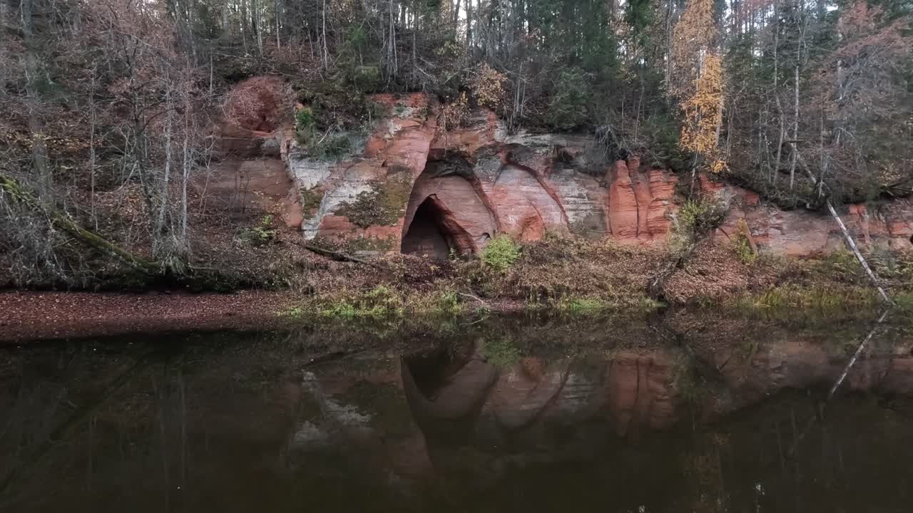 cueva de los ángeles, un acantilado de arenisca roja en forma de alas de ángel, en el río salaca en el parque natural skanaiskalns en mazsalaca, letonia, tiempo de otoño