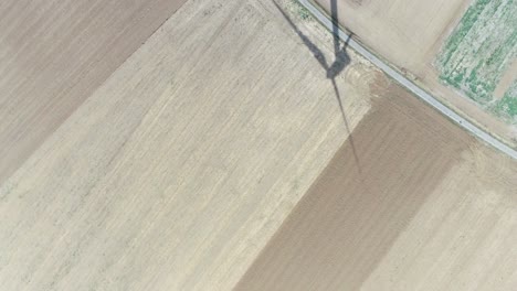 drone shot of farmland and windmill with shadow