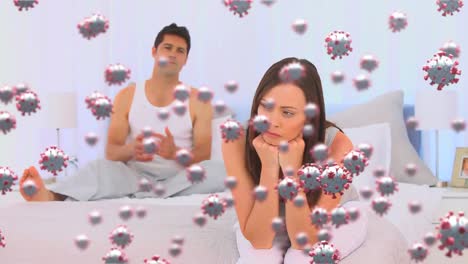video compuesto digital de células de covid-19 moviéndose contra una pareja que lucha en la cama en el fondo