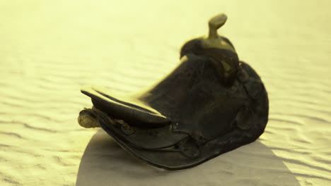 sculpture of a traditional hat resting on a sandy surface during sunset