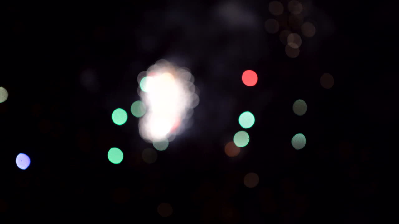 Celebrating with out of focus fireworks on beach for 4th of July