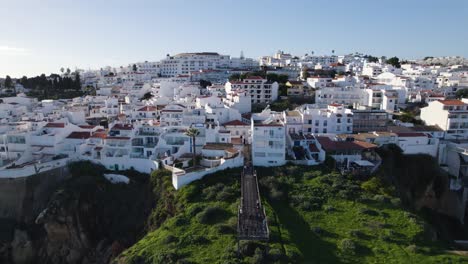 Antena-Panorámica-Que-Establece-Una-Visión-General-De-Los-Edificios-De-Casas-De-Lujo-Con-Paredes-Blancas-En-Los-Acantilados-De-Albufeira,-Portugal,-Con-Vistas-Al-Océano