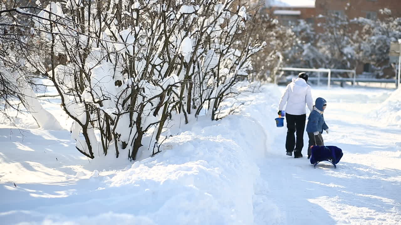 Mother walking with son. Small child and mother in the winter outside in warm clothes