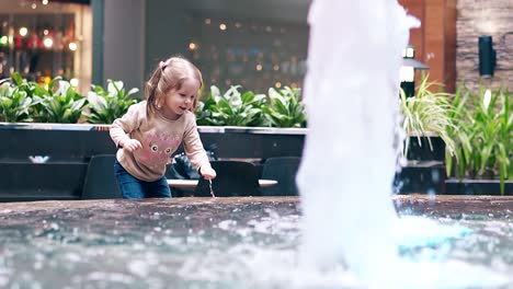 slow motion little sweet girl playing with water near fountain 1