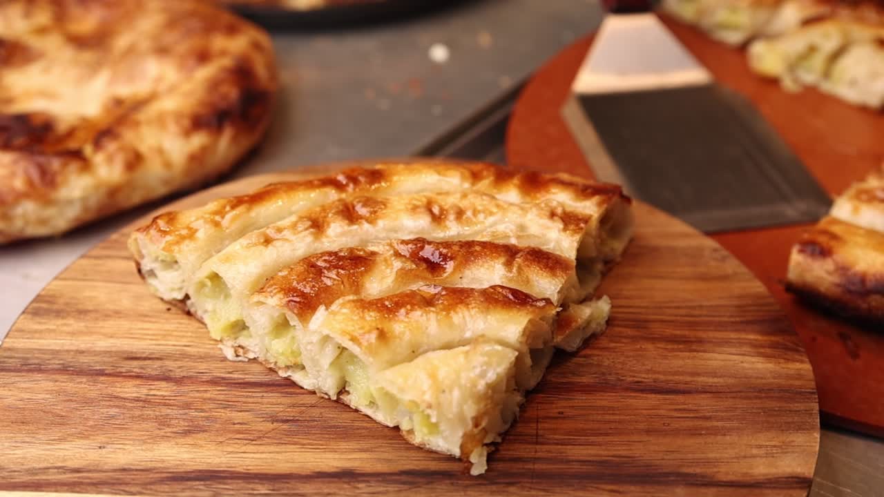 Primer plano de una rebanada de pastel salado dorado y hojaldrado.