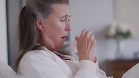 sick woman with tissue coughing at home