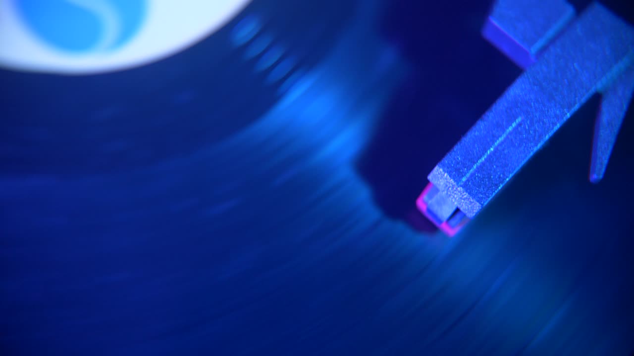 Agulha de toca-discos reproduzindo disco de vinil com luzes neon mutáveis