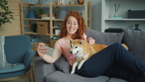 woman taking selfie with her dog on couch