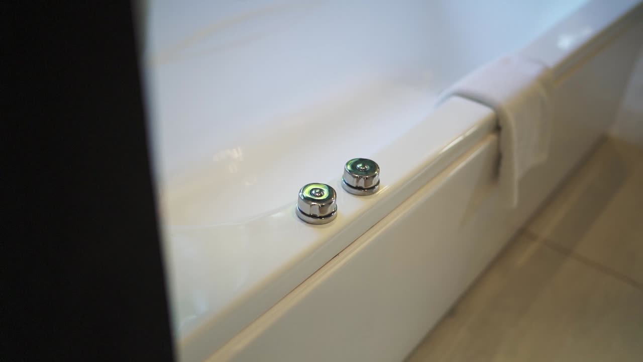 Close-up view about a modern bathroom fixtures on a ceramic bathtub rim, Argentina.