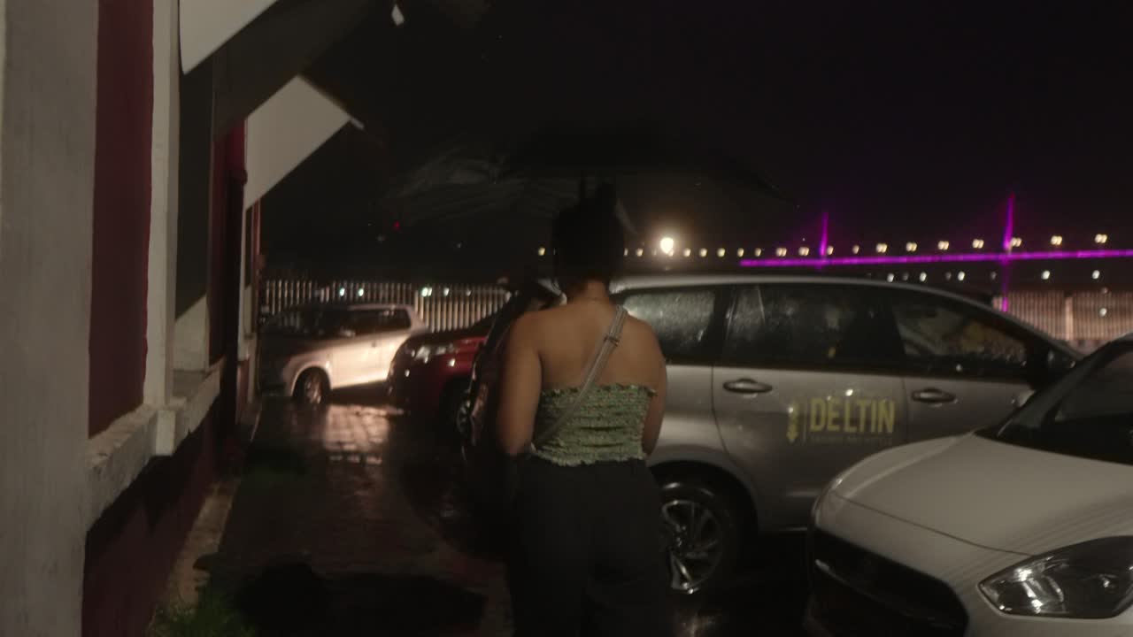 Woman walking in the rain at night