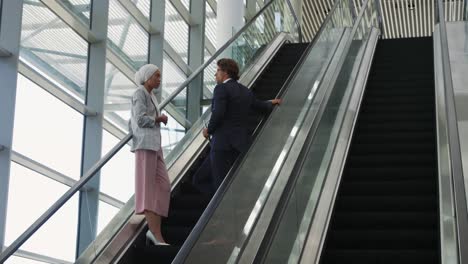 Young-business-people-on-an-escalator-in-a-modern-building