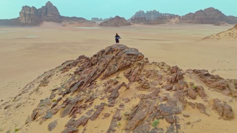Revelación-De-Retroceso-De-Una-Turista-Parada-Sobre-Una-Roca-En-El-Desierto-De-Wadi-Rum,-Aqaba,-Jordania