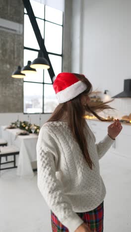 una mujer con un sombrero de santa y un pijama a cuadros, celebrando la navidad.