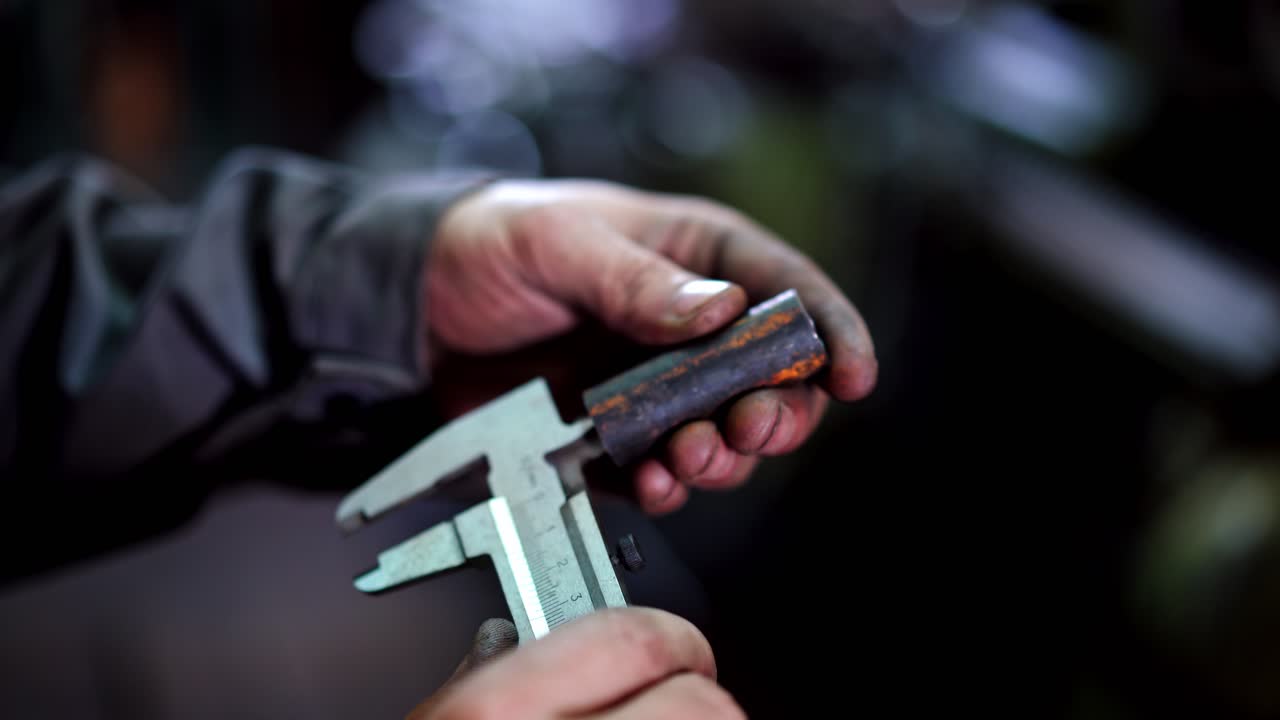 Industrial Worker With Vernier Caliper. Factory man worker measuring steel detail with caliper at workshop